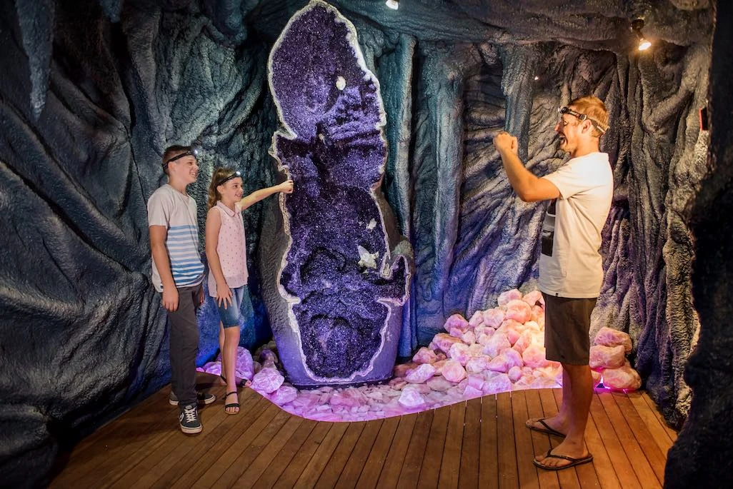 Family admiring the giant amethyst geode inside Crystal Caves